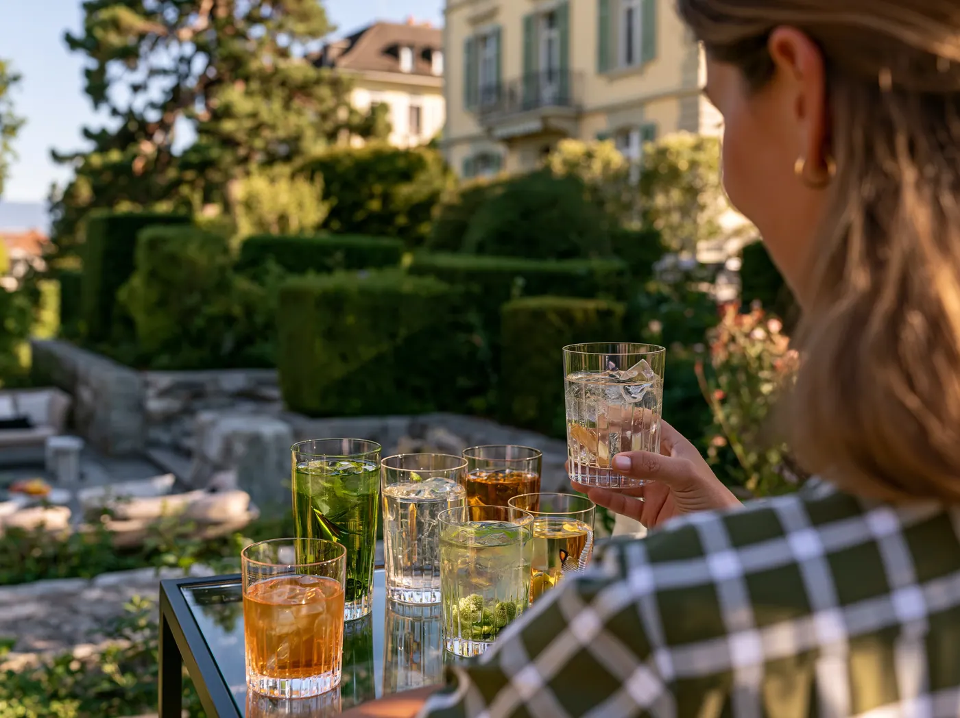 Inga prüft eine Auswahl alkoholfreier Apéritifs im Garten